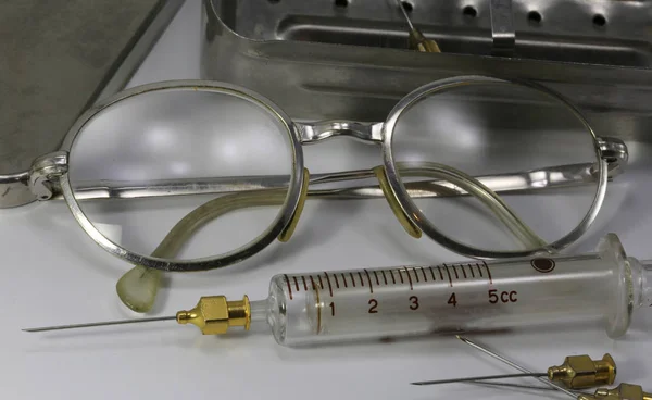 Vecchi occhiali vintage di un medico e la siringa di vetro — Foto Stock