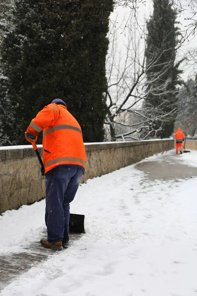 Sweeper on the sidewalk as he shovels the snow — Stock Photo, Image