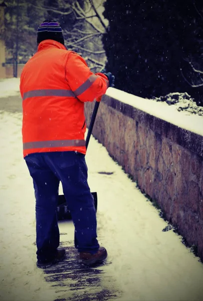 Scavatrice neve con gilet ad alta visibilità spalare il marciapiede arguzia — Foto Stock