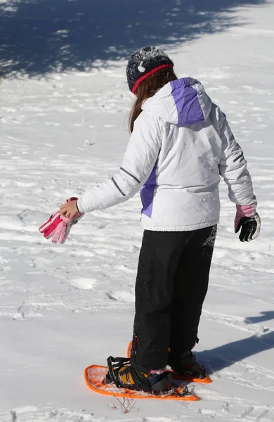 Kleines Mädchen mit orangefarbenen Schneeschuhen Stockfoto