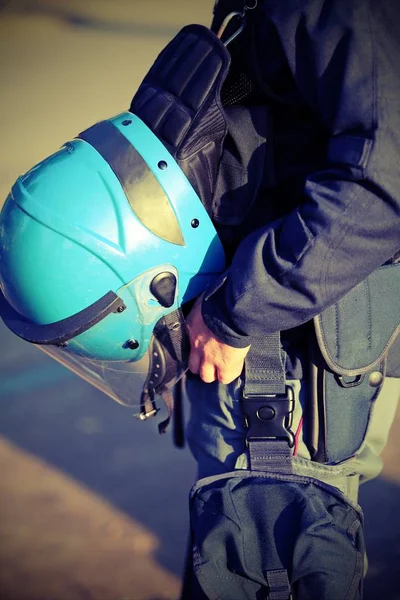 Голубой шлем полицейского в спецодежде во время восстания с — стоковое фото