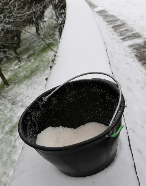 bucket with salt used to melt ice and snow from the sidewalk