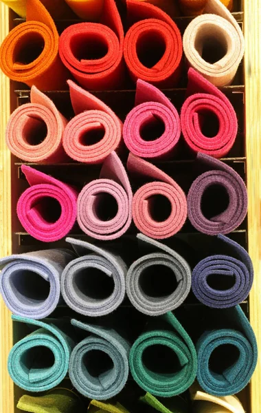 colored big rolls of fabric in the shelf of the tailoring