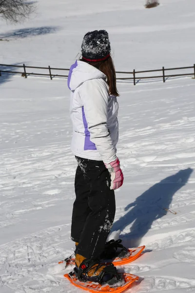 Dziewczynka z rakiety śnieżne i długie włosy zimą — Zdjęcie stockowe
