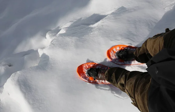 Yüksek mou içinde derin bir yarık yakınındaki insan turuncu kar ayakkabıları ile yürüyor — Stok fotoğraf