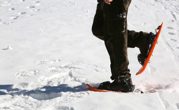 Hombre con raquetas de nieve en nieve blanca en invierno —  Fotos de Stock