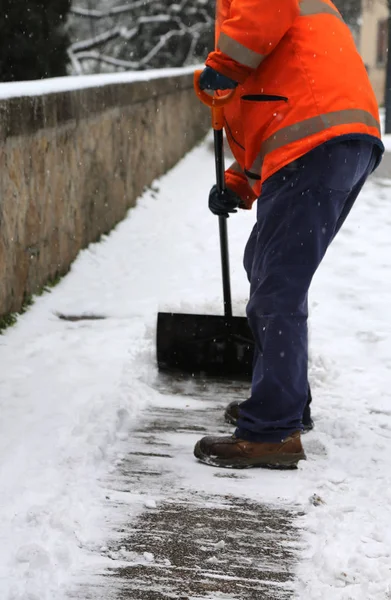 Εργαζόμενος ενώ φτυαρίζει το χιόνι από παγωμένο πεζοδρόμιο — Φωτογραφία Αρχείου