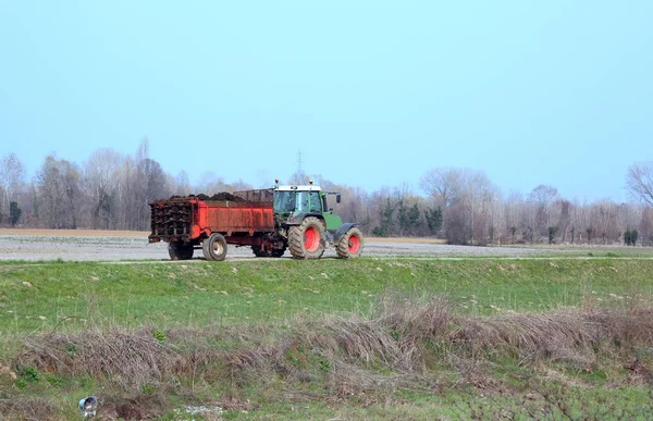 Tractor con un carro lleno de estiércol — Foto de Stock