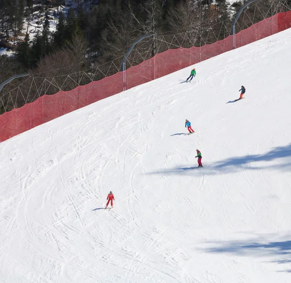 Esquiadores com roupas de inverno na pista de esqui — Fotografia de Stock