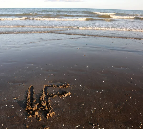 IF text written on the sand of the beach near the sea — Stock Photo, Image