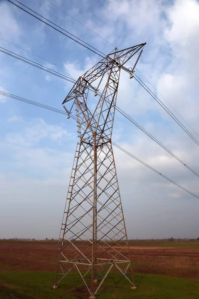 Geniş düz ve elektrik kabloları ile bir yüksek gerilim pilon — Stok fotoğraf