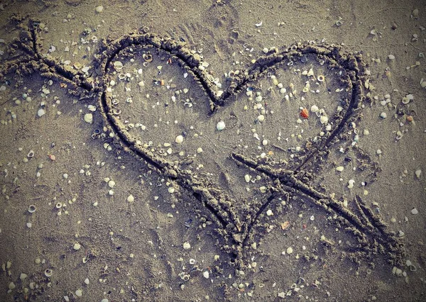 Simbolo del cuore con freccia sulla spiaggia vincere effetto vintage — Foto Stock