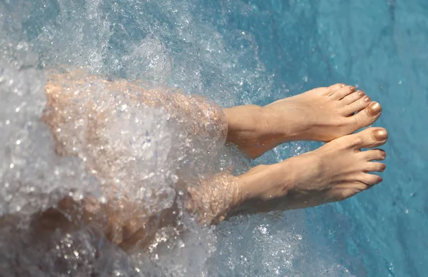 Twee voeten van een jonge vrouw tijdens de sessie hydromassage — Stockfoto
