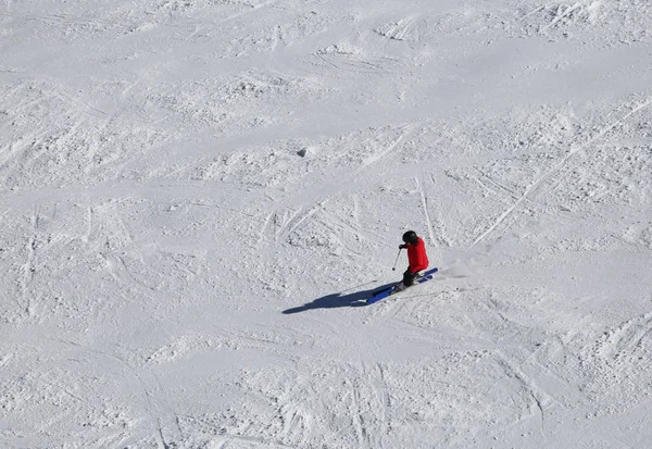 Kayakçı kayak pisti üzerinde azalan ise kırmızı elbiseli — Stok fotoğraf