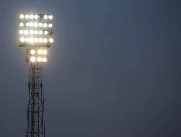 Holofotes de um estádio de futebol iluminado para iluminar o campo — Fotografia de Stock