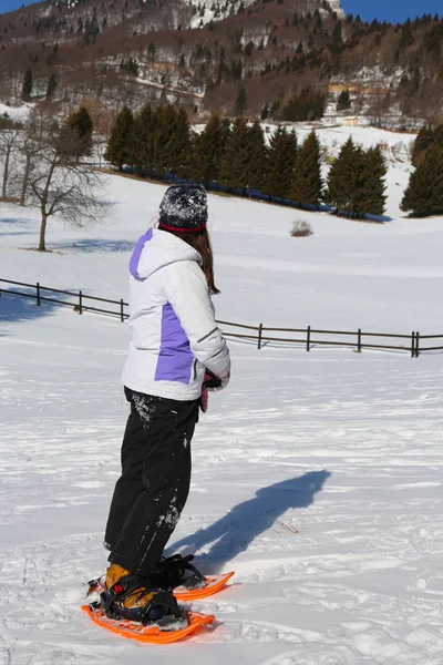 Liten flicka med snöskor slutar för att titta på horisonten — Stockfoto