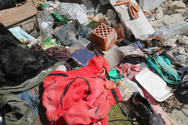 Sudadera roja en medio de montones de basura y muchos trapos en un — Foto de Stock