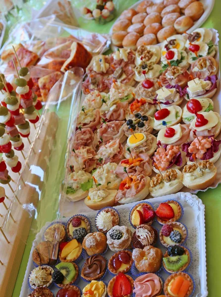 Reichhaltiges Buffet mit süßem Gebäck und gefüllten Sandwiches — Stockfoto