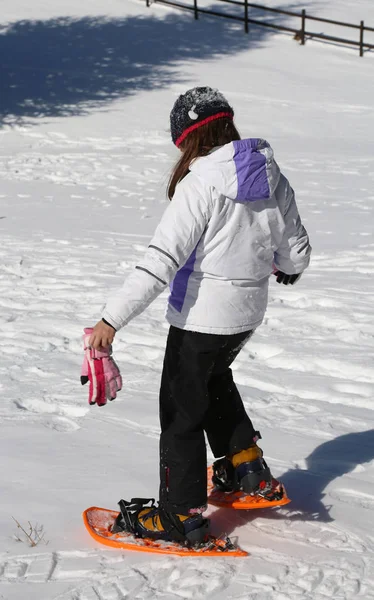 Liten flicka försöker snöskor — Stockfoto
