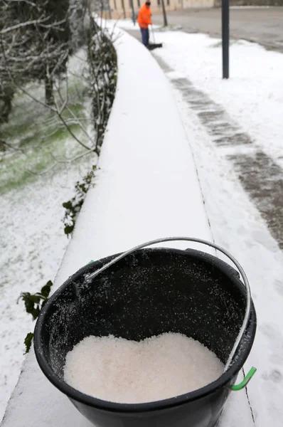 Ведро соли, используемое для таяния льда и снега с тротуара — стоковое фото