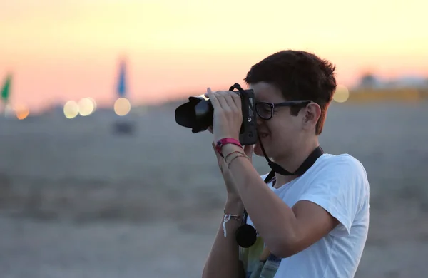 Jovem fotógrafo menino em uma praia o pôr do sol no mar — Fotografia de Stock