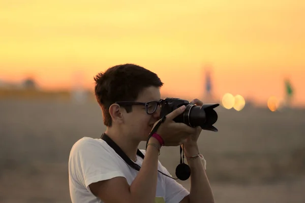 Jovem menino tira uma foto com a câmera — Fotografia de Stock