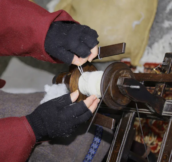 Mãos de uma senhora idosa que costurar usando uma roda de fiação — Fotografia de Stock