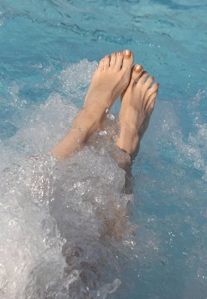 Fötter av kvinna under terapin bubbelpool i spa-poolen — Stockfoto