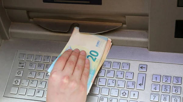 Boy takes money at atm machine in european city — Stock Photo, Image