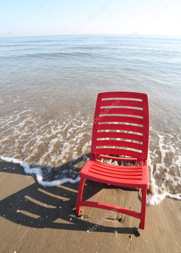 red chair is bathed by the sea
