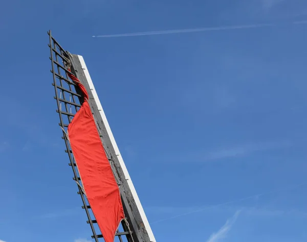 Röd spade en väderkvarn och den blå himlen — Stockfoto