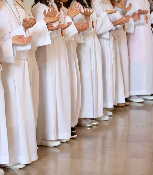 Crianças durante a primeira comunhão com túnicas durante o santo — Fotografia de Stock