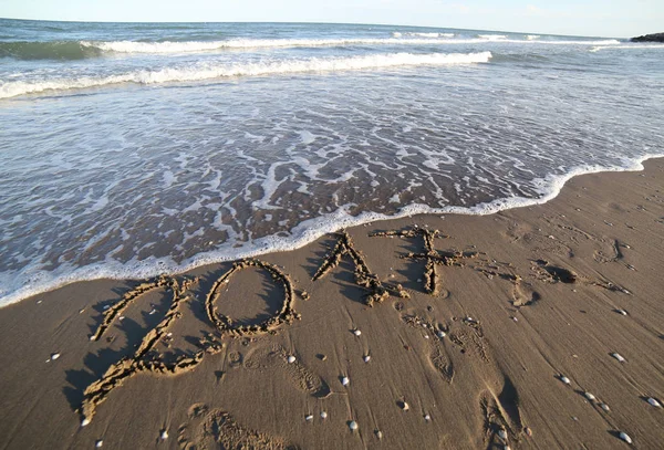 Text 2017 på stranden och vågorna i havet — Stockfoto