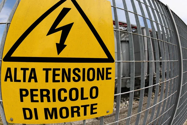 Letrero en la central eléctrica con texto que significa ALTO VOLTAGE — Foto de Stock