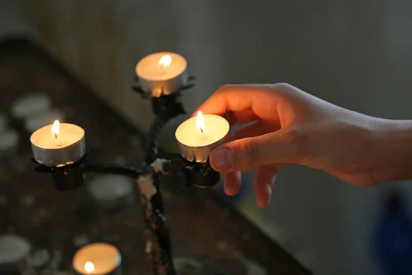 Junge legt eine Kerze mit der Hand — Stockfoto