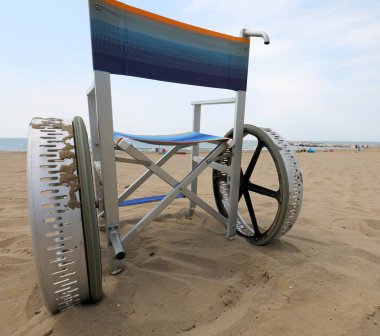 Kumsalda hareket etmek için geniş tekerlekleri olan özel tekerlekli sandalye.