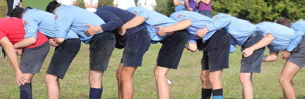 Muitos menino com uniforme de olheiro jogando no salto sapo ao ar livre — Fotografia de Stock