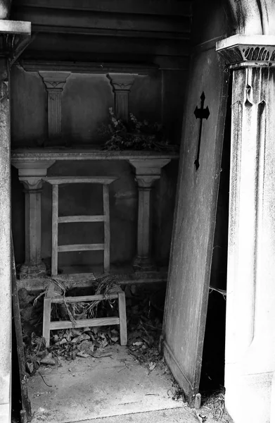 Porta desarticulada e cadeira quebrada no lóculo do cemitério — Fotografia de Stock