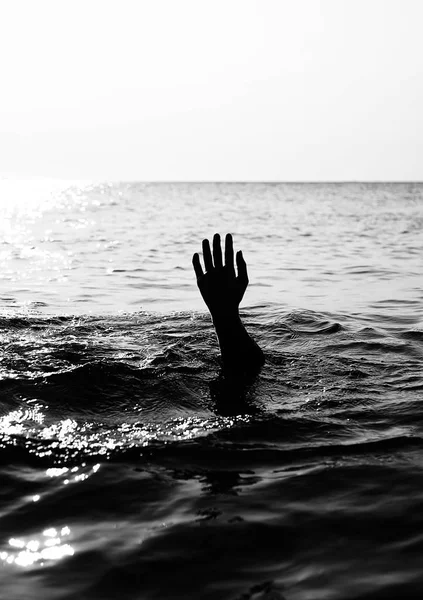 Рука людини на чорному океані — стокове фото