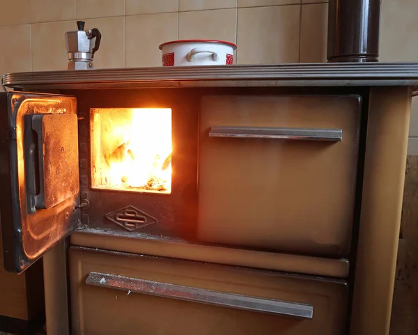 Fuoco di una vecchia stufa nella piccola cucina — Foto Stock