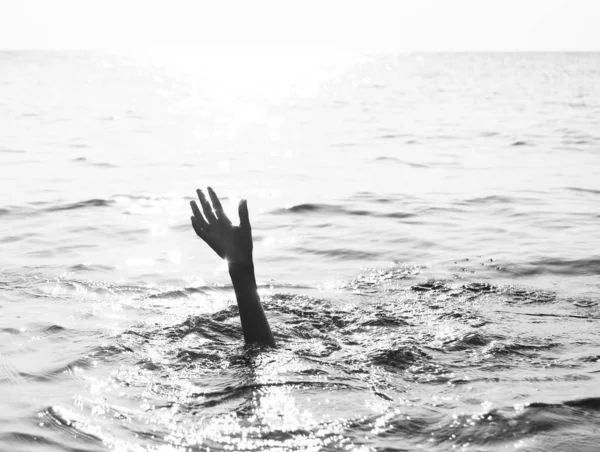 Рука людини на океані з драматичним тонованим ефектом — стокове фото