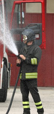 Tatbikat sırasında üniformalı itfaiyeci.