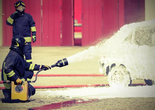 Πυροσβέστες σβήνουν μια φωτιά σε ένα αυτοκίνητο — Φωτογραφία Αρχείου