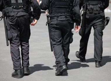 Üç polis yolda devriye geziyor.