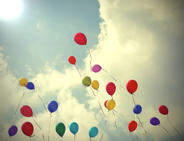 Muitos balões voando no céu azul com nuvens durante uma festa — Fotografia de Stock