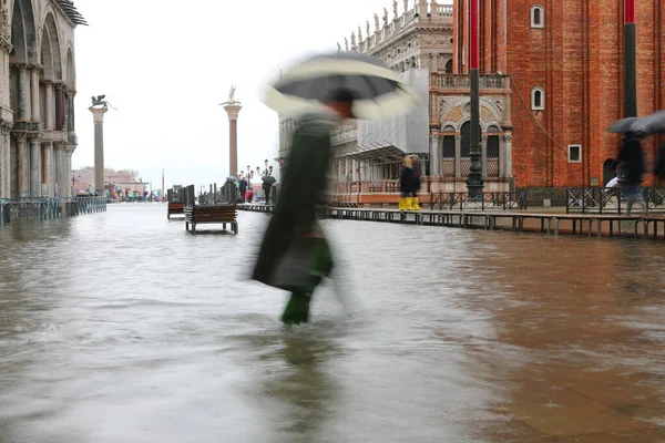 person with umbrella during the flood in Venice in Italy and the