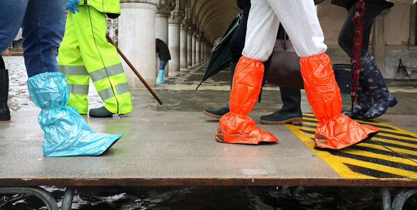 много людей на пешеходном мосту с пластиковыми гаишниками в Венице в
 