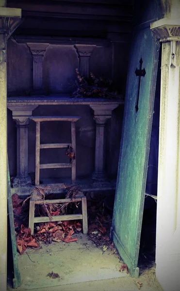 Wyłamane drzwi i uszkodzone krzesło na cmentarzu — Zdjęcie stockowe