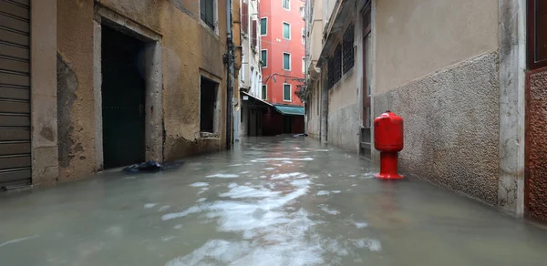 Červený hydrant na zaplavené úzké ulici v Benátkách — Stock fotografie