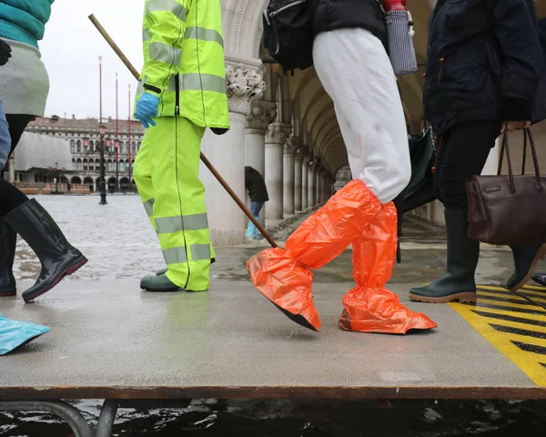 Many people on the footbridge with plastic gaiters in Venice in — Stock Photo, Image